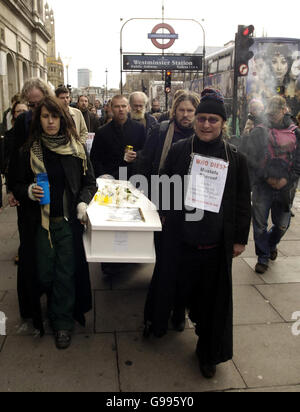 I membri del London Catholic Workers Group trasportano una bara in una processione funeraria che rappresenta il massacro degli Innocenti dell'Iraq, a Whitehall, Londra, domenica 2 aprile 2006. I manifestanti si sono riuniti oggi al di fuori delle Camere del Parlamento per leggere i nomi di 1,000 civili iracheni presumibilmente uccisi dalle forze della coalizione. Una folla di circa 150 persone, con striscioni anti-guerra e tamburi che battono, ha ascoltato come le circostanze delle morti degli ultimi tre anni sono state lette in Piazza del Parlamento. Vedi la storia della PA PROTESTA l'Iraq. PREMERE ASSOCIAZIONE foto. Il credito fotografico dovrebbe essere: Andrew Stuart/PA Foto Stock