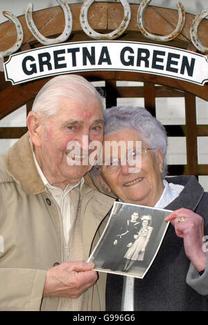 Coppia di nozze di diamante Ronald Woodard 84 e Muriel Woodard 83 con una fotografia dal loro giorno di nozze in 1956, a Gretna Green Mercoledì 5 aprile 2006. 25 coppie che celebrano il loro anniversario di matrimonio Diamante e dorato si sono recate a Gretna Green per essere benedette sopra l'incudine originale nel famoso negozio di fabbri, tra loro costituiscono 1250 anni di vita sposata. Guarda Gretna STORIA SOCIALE PA. PREMERE ASSOCIAZIONE FOTO. IL CREDITO FOTOGRAFICO DOVREBBE ESSERE DANNY Lawson /PA Foto Stock