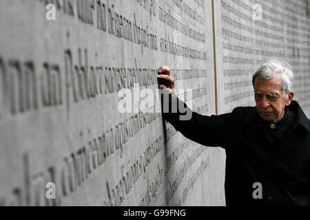 Padre Joseph Mallin, un figlio di Michael Mallin uno dei leaders 1916 tocca il Memorial Wall al 1916 plot durante l annuale 1916 Pasqua Cerimonia di commemorazione a massa Arbour Hill Chiesa, Dublino. Foto Stock