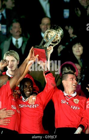 I Manchester United's Quinton Fortune (a sinistra), David Beckham (a sinistra), Dwight Yorke (al centro) e Roy Keane (a destra) festeggiano con la Coppa Intercontinentale Foto Stock