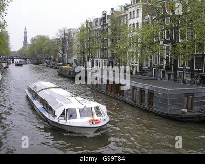 Imbarcazione turistica passa attraverso un canale di Amsterdam. Foto Stock