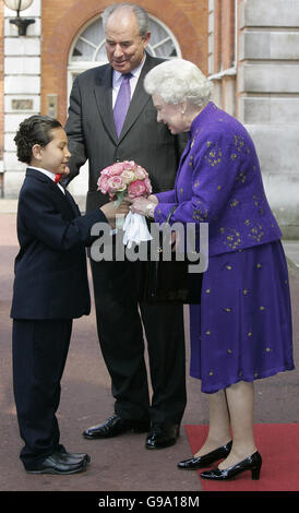 La Regina Elisabetta II della Gran Bretagna, accompagnata dal Segretario Generale del Commonwealth Don McKinnon, Center, riceve fiori da un giovane ospite alla Marlborough House nel centro di Londra. Foto Stock