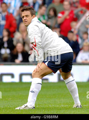 Il capitano della squadra inglese Robbie Williams, durante la partita di calcio benefica dell'UNICEF Soccer Aid, a Old Trafford, Manchester. Foto Stock