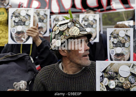 Anti-guerra protestor Brian Haw a Londra in piazza del Parlamento con i suoi sostenitori, che maschera le loro facce con una fotografia del signor Haw. La Corte Suprema ha emesso una sentenza che egli non è in grado di continuare la sua lunga veglia in piazza ma egli è attraente la decisione e ha il permesso di rimanere fino a quando la sua audizione. Foto Stock