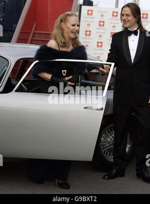 Ursula Andress è aiutata dall'auto del figlio Dimitri Hamlin dopo l'arrivo nell'originale James Bond Aston Martin DB5 da 'Goldfinger' al Royal Yacht Britannia di Edimburgo per celebrare il suo compleanno. L'occasione segna anche l'opnening del Consolato generale svizzero a Edimburgo. Foto Stock