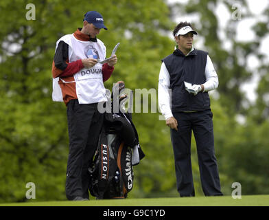 L'inglese Nick Dougherty (a destra) aspetta di giocare il suo secondo colpo durante il secondo round del campionato BMW al Wentworth Golf Club, Virginia Water, Surrey. Foto Stock