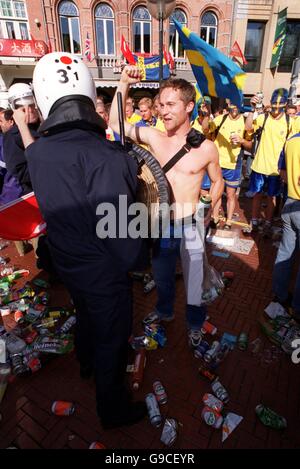 Calcio - Euro 2000 - Gruppo B - Svezia / Turchia. Un fan svedese sbatte un poliziotto in preda allo scoppio di violenze nella piazza della città Foto Stock