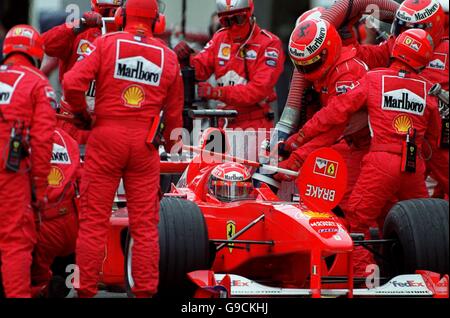 L'equipaggio Ferrari lavora sulla vettura di Michael Schumacher durante un pit stop Foto Stock