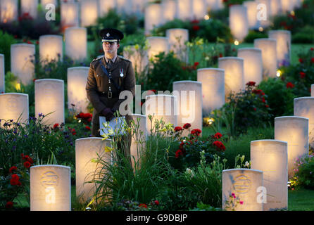 Un soldato stand tra acceso delle tombe di guerra durante un militare veglia a led per commemorare il centesimo anniversario dell inizio della battaglia della Somme presso il memorial Thiepval al mancante, come parte della commemorazione del centenario della Battaglia delle Somme presso la Commissione delle tombe di guerra del Commonwealth Thiepval Memorial in Thiepval, Francia, dove 70.000 British and Commonwealth soldati con noto alcun grave sono commemorati. Foto Stock