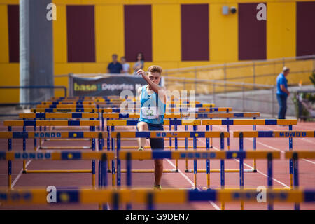 Sport ragazzo facendo Hurdling su una pista di atletica Foto Stock