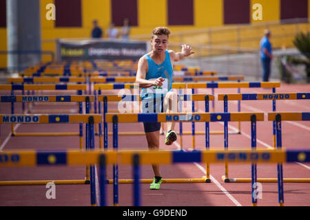 Sport ragazzo facendo Hurdling su una pista di atletica Foto Stock