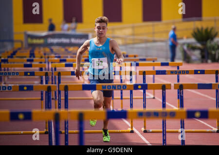 Sport ragazzo facendo Hurdling su una pista di atletica Foto Stock