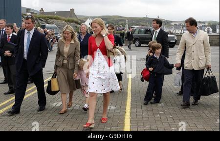 Gli ospiti della Regina Elisabetta II, tra cui Peter Phillips (davanti a sinistra), la sua fidanzata Autumn Kelly (davanti al centro) e il visconte Linley (a destra) arrivano per imbarcarsi sulla Principessa Ebrida a Port Ellen su Islay, per una crociera di una settimana intorno alle Isole Occidentali per celebrare l'ottantesimo compleanno della Regina. Foto Stock