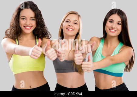 Ritratto di tre belle e atletico ragazze con pollice in alto Foto Stock