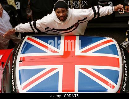 Lennox Lewis, campione di pesi massimi WBC, si erge accanto a un mini con tetto Union Flag, all'esterno di Cabot Hall, Canary Wharf Foto Stock