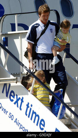 David Beckham, che ha tenuto suo figlio Cruz, e con suo figlio Romeo all'aeroporto di Stansted in Essex come la squadra di calcio dell'Inghilterra per ritornare dalla Germania dopo che sono stati abbattuti ieri dalle finali del quarto della Coppa del mondo dal Portogallo. Foto Stock