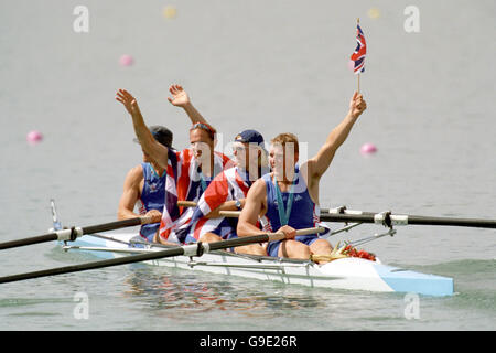 La squadra vincitrice d'oro della Gran Bretagna (L-R ) James Cracknell, Steve Redgrave, Tim Foster e Matthew Pinsent festeggiano con union jacks Foto Stock