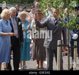 La Duchessa di Cornovaglia guarda il Principe del Galles ondare una vanga dopo una cerimonia di piantagione di alberi in Tetbury, Gloucestershire. Foto Stock