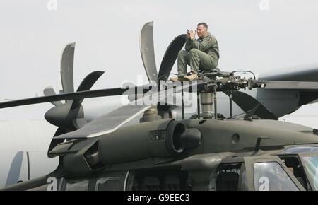 Un membro della USAF si siede su un elicottero Black Hawk per guardare la mostra Airbus A380 al Farnborough Airshow. Foto Stock