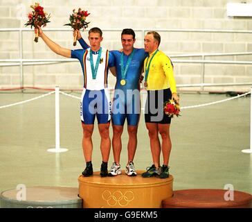 Jason Queally (c) della Gran Bretagna celebra la vittoria dell'oro nella prova a tempo da 1 km degli uomini. Alla sua sinistra si trova il vincitore della medaglia d'argento tedesco Stefan Nimke e il vincitore della medaglia di bronzo di destra Shane Kelly d'Australia Foto Stock