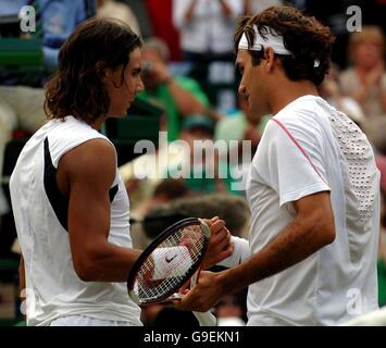 Roger Federer (a destra), in Svizzera, stringe le mani con il spagnolo Rafael Nadal durante l'All England Lawn Tennis Championships a Wimbledon. Foto Stock