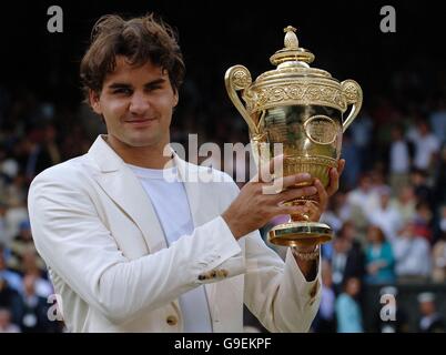 Roger Federer in Svizzera festeggia con il trofeo dopo aver sconfitto il spagnolo Rafael Nadal durante i Campionati di tennis all England Lawn a Wimbledon. Foto Stock