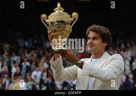 Roger Federer in Svizzera festeggia con il suo trofeo dopo aver sconfitto il spagnolo Rafael Nadal durante i Campionati di tennis all England Lawn a Wimbledon. Foto Stock