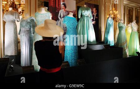 Abiti da vestire per l'occasione, una mostra di abiti da sera e gioielli indossati dalla Regina Elisabetta II durante occasioni di stato sul display in camere di stato a Buckingham Palace di Londra per la sua apertura estiva da domani. Foto Stock