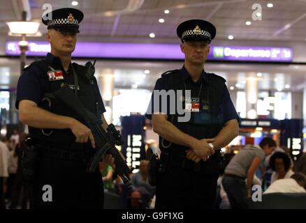 Poliziotto in servizio al Terminal 1 dell'aeroporto di Manchester dopo che un complotto terroristico per far esplodere un aereo a mezz'aria è stato ingannato dalla polizia e dai servizi di sicurezza, ha detto oggi il Segretario dell'interno John Reid. Foto Stock