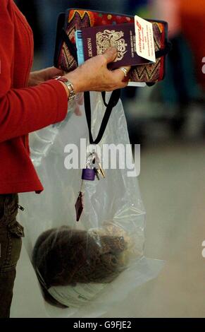 Una signora trasporta i bagagli a mano in una borsa di plastica prima di entrare nel controllo dei passaporti all'aeroporto Stansted di Londra, Essex, dopo che UN "molto significativo" complotto terroristico per far esplodere gli aerei a mezz'aria è stato ingannato dalla polizia e dai servizi di sicurezza, ha detto oggi il Segretario dell'abitazione John Reid. Foto Stock