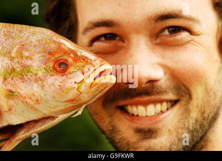 Ben Fillmore, di 24 anni, proveniente da Wood Green, a nord di Londra, viene introdotto in un Pacific Red Snapper, mentre si prepara a ricevere schiaffo per beneficenza da chiunque faccia la più alta offerta su e-Bay. Foto Stock