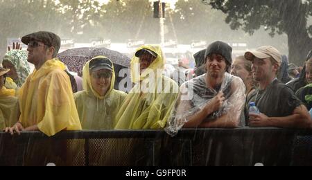 Appassionati di musica bagnata dalla pioggia al V Festival di Hylands Park a Chelmsford, Essex. Foto Stock