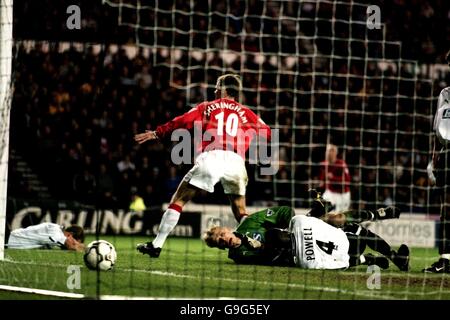 Calcio - fa Carling Premiership - Derby County contro Manchester United. Teddy Sheringham (c) del Manchester United celebra il primo gol del gioco mentre la difesa della contea di Derby è lasciata sul pavimento Foto Stock