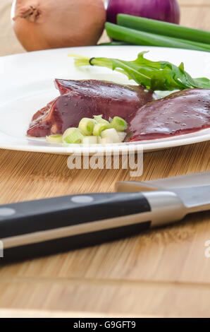 Materie di fegato di pollo con verdure su sfondo di legno Foto Stock