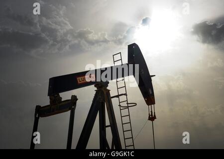 Pumpjack aka cavallo di olio, annuendo asino, olio jack, fascio solleva pompa olio grezzo nel deserto del Bahrain a Sakhir sul Golfo Persico Foto Stock