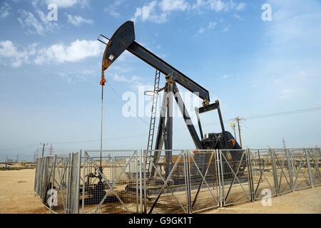 Pumpjack aka cavallo di olio, annuendo asino, olio jack, fascio solleva pompa olio grezzo nel deserto del Bahrain a Sakhir sul Golfo Persico Foto Stock