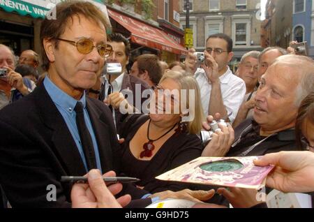 Cliff Richard firma autografi ai tifosi mentre si unisce ad una serie di altri cantanti e musicisti mentre commemorano quello che era il 2i's Coffee Bar, una caffetteria e un locale di musica negli anni '50, sulla Old Compton Street a Soho, nel centro di Londra. PREMERE ASSOCIAZIONE foto. Data immagine: Lunedì 18 settembre 2006. Il sito, che ora ospita Boulevard Bar & Dining Room, stava avendo una targa svelata come è accreditato di essere il luogo di nascita del rock and roll britannico. Westminster City Council ha montato una delle sue placche verdi in onore del 2i's Coffee Bar e il suo contributo unico alla storia di Foto Stock