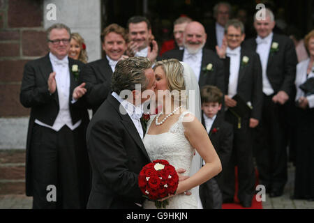 La star del River Dance Michael Flatley bacia sua moglie Niamh o'Brien mentre la coppia lascia la chiesa di San Patrizio a Fermoy, Co Cork, dopo il loro matrimonio di oggi. Foto Stock