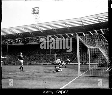 Portiere della Scozia Bill Brown (al piano) guarda come la palla vola verso l'alto Foto Stock