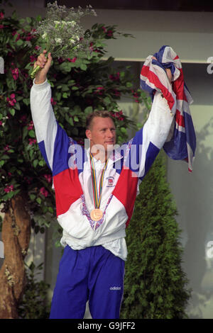 Giochi Olimpici di Barcellona 1992 - Nuoto - corsa al seno da 200 metri - cerimonia Medaglia. Nick Gillingham della Gran Bretagna festeggia con una bandiera dell'Unione dopo aver vinto la medaglia di bronzo nel colpo di seno di 200 metri degli uomini. Foto Stock