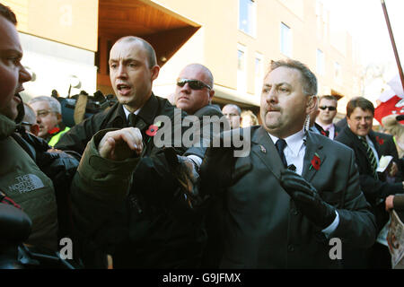 Un team di sicurezza respingerà i membri della stampa, mentre il leader del BNP Nick Griffin, all'estrema destra, arriva oggi alla Leeds Crown Court per l'inizio del suo processo di ripetizione sulle accuse di incitare l'odio razziale. Foto Stock