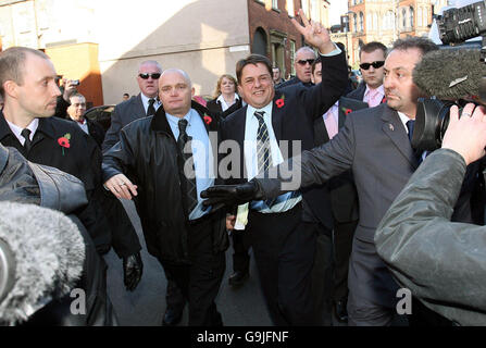 Il leader del BNP Nick Griffin (sventolando) arriva oggi alla Crown Court di Leeds per l'inizio del suo processo sulle accuse di incitare l'odio razziale. Foto Stock