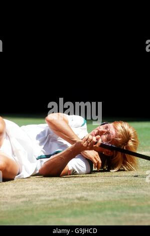 Tennis - Wimbledon Championships 1987 - finale femminile singolare - Martina Navratilova v Steffi Graf. Martina Navratilova giace a terra dopo essersi disteso per raggiungere un colpo Foto Stock