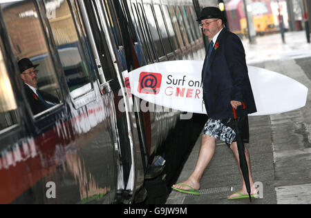 Un attore con una tavola da surf è a bordo di un treno GNER, come l'operatore del treno della costa orientale completa oggi l'installazione di internet senza fili per la sua intera flotta di treni. Foto Stock