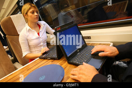Due membri del pubblico usano i laptop a bordo di un treno GNER, mentre l'operatore ferroviario della costa orientale completa oggi l'installazione di internet wireless per tutta la sua flotta di treni. Foto Stock