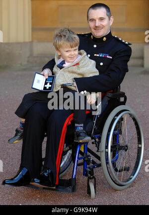 Disabilitata la guerra di Iraq bomba vittima, capitano Pietro Norton del Royal Logistics Corp con la sua Croce di San Giorgio dopo la raccolta dalla Principessa Reale, che è stato in piedi per la Regina Elisabetta II, durante una cerimonia di investitura a Buckingham Palace di Londra oggi. Egli è accompagnato da suo figlio Tom, 3. Stampa foto di associazione. Picture data giovedì 2 novembre 2006. ROTA Photo credit dovrebbe leggere Fiona Hanson/PA Foto Stock