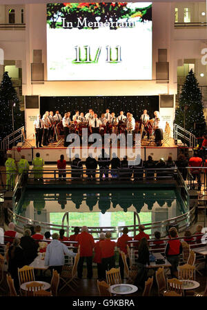 Il personale, i clienti e la band dell'Esercito della salvezza prendono parte a due minuti di silenzio al Trafford Centre, Manchester, in omaggio ai morti di guerra del paese. Foto Stock