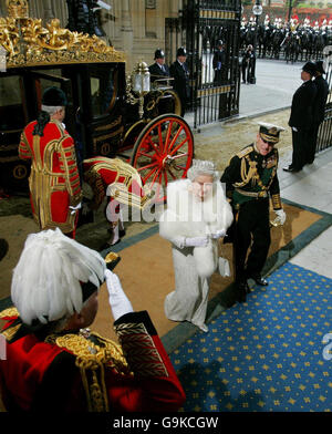 La regina Elisabetta II, centro a sinistra, e suo marito Duca di Edimburgo, si allontanano dalla carrozza della regina quando arrivano al Palazzo di Westminster a Londra per l'apertura di Stato del Parlamento. Foto Stock