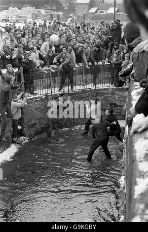 Royal Shrovetide Football Match - Ashbourne, Derbyshire. La palla è gettata in Henmore Brook Foto Stock