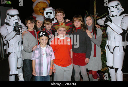 I membri di Angelis (fila posteriore) incontrano i pazienti di Great Ormond Street Lenny (davanti a destra) & Harry (davanti a sinistra), insieme ad alcuni Stormtroopers, alla festa di Natale dell'ospedale nel nord di Londra. Foto Stock